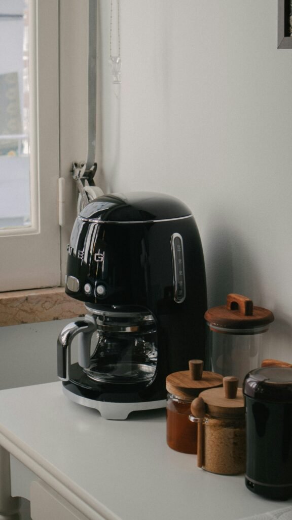 A black basket-style air fryer standing on a white kitchen counter