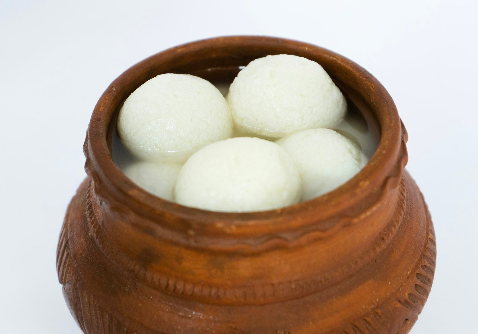 Soft white rasgullas in a terracotta pot