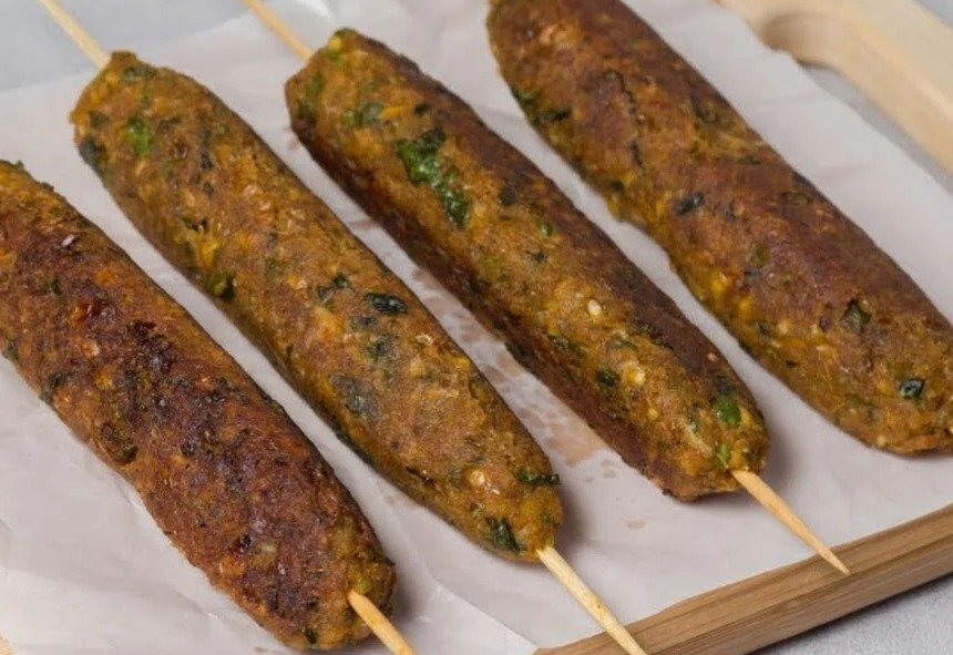 Golden Corn and Peas Seekh Kebabs on wooden skewers, flecked with mint and coriander, made by Siddhi Panchal