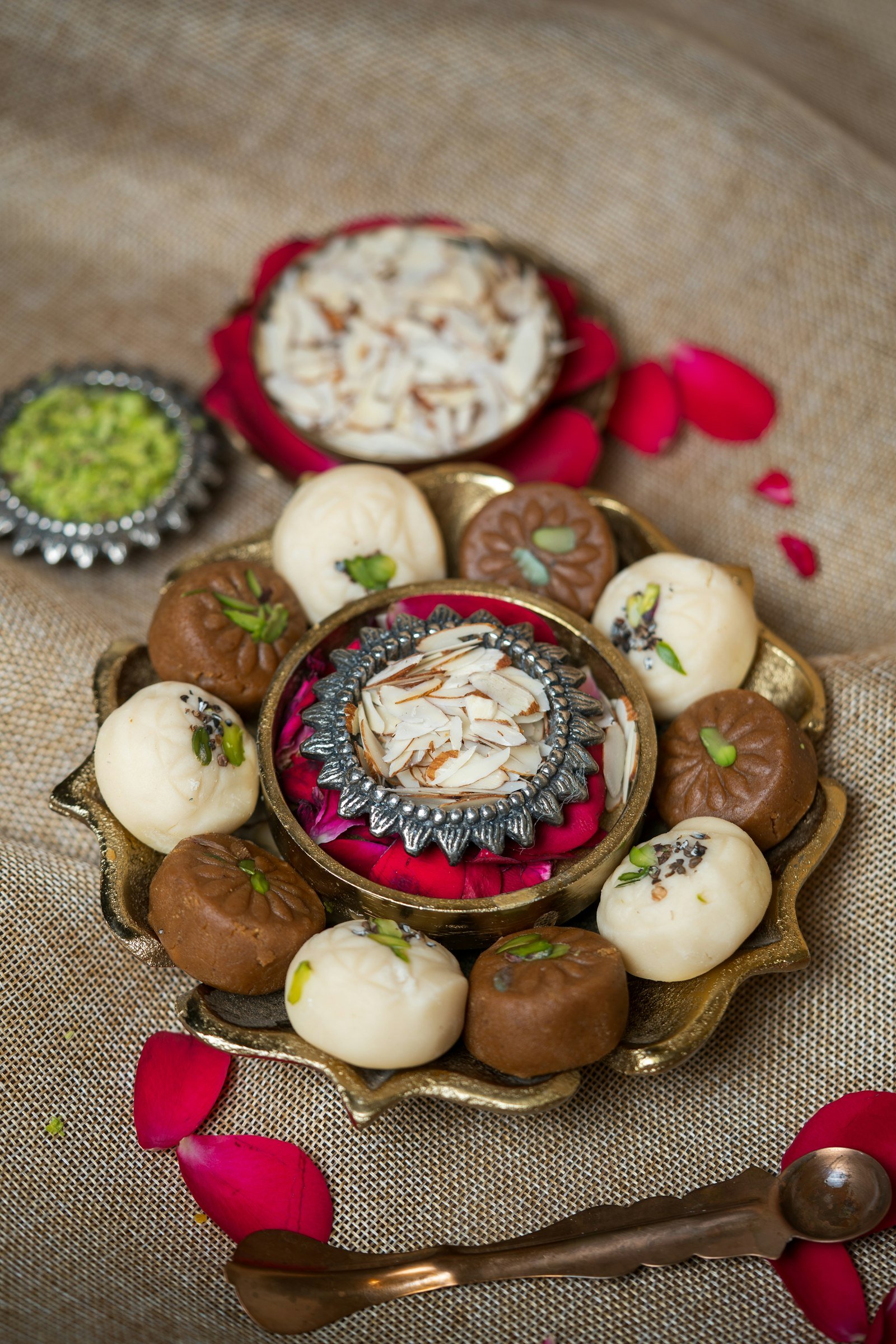 A festive platter of assorted Indian sweets decorated with rose petals