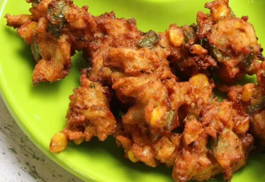 Crispy pasta pakoda with sweet corn on a green plate