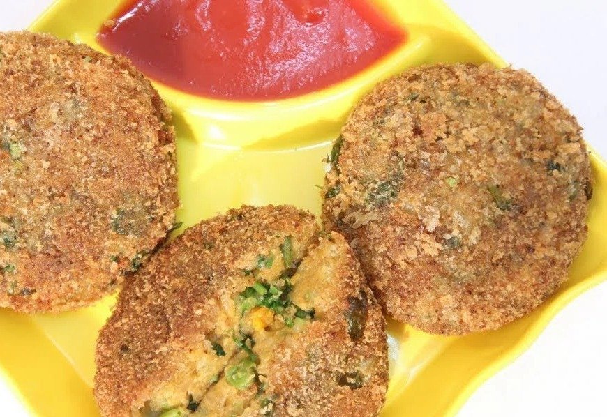 Crispy veg kababs coated in bread crumbs on a yellow plate with ketchup